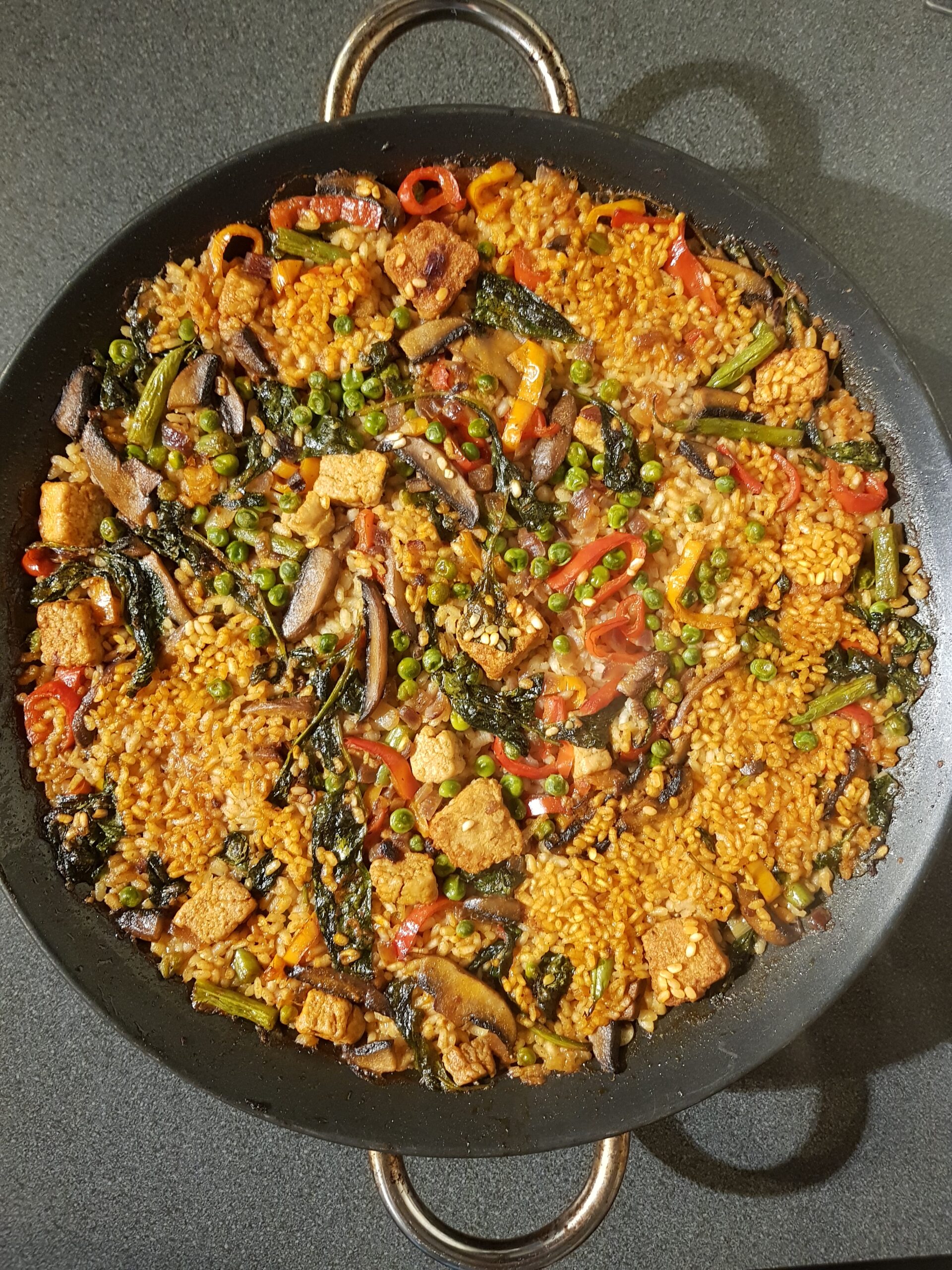 A dish of Vegan Paella with spicy paprika vegan sausages and mushrooms