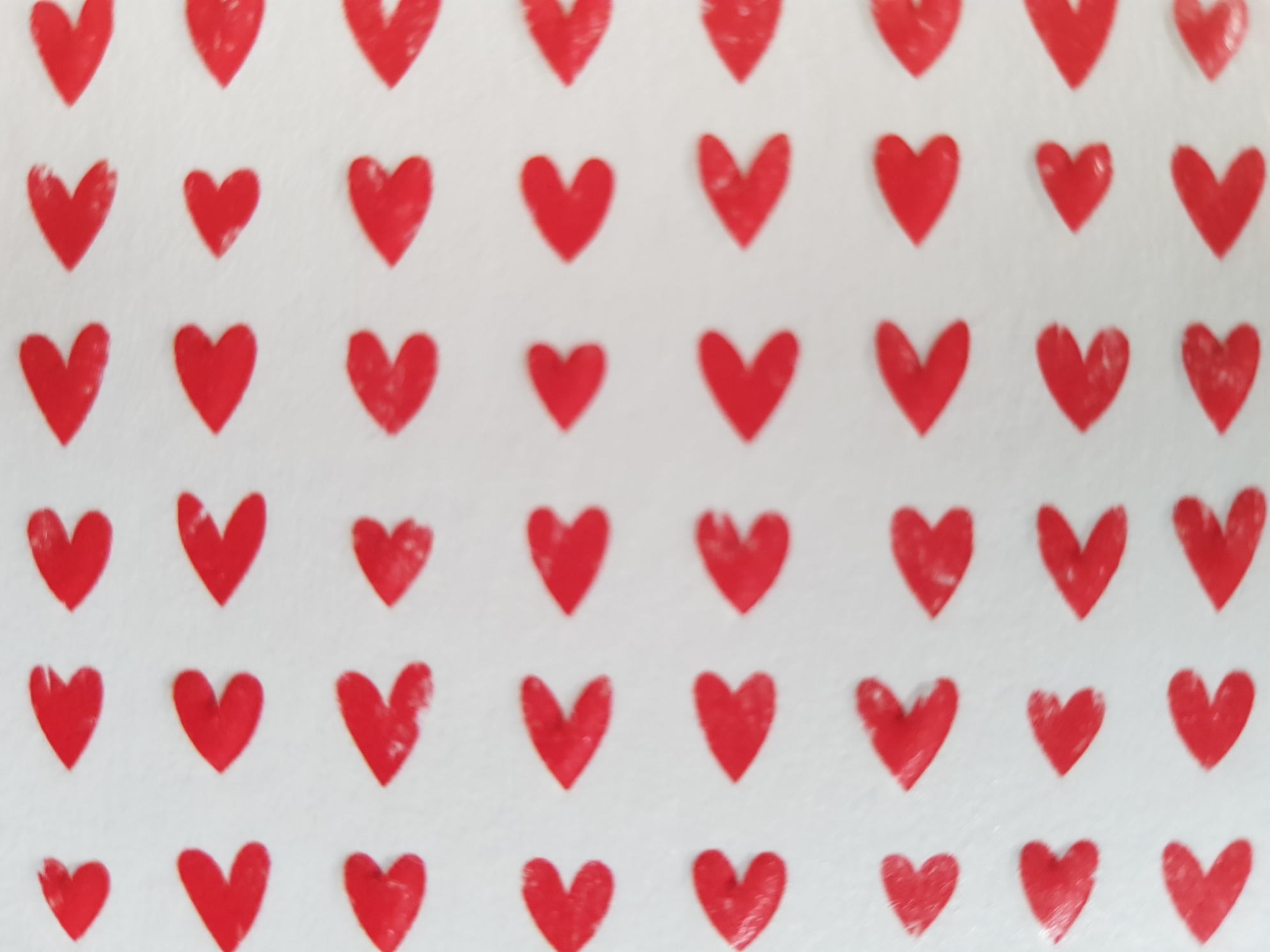 Image of rows of small red hearts painted onto white card