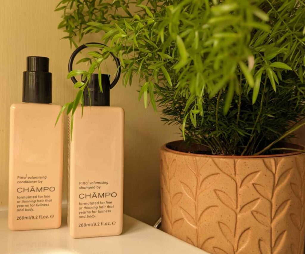 2 beige plastic bottles containing Pitta by Champ shampoo and conditioner